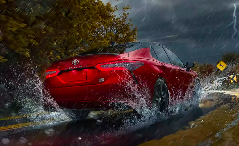 2022 toyota camry whizzing down a rainy street