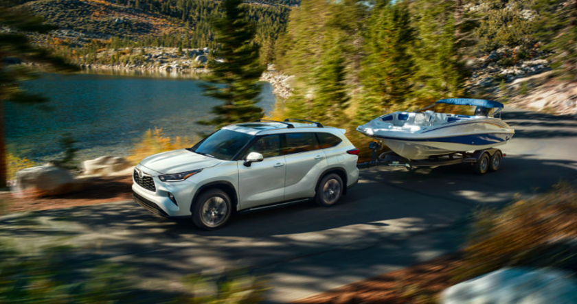 White 2023 Toyota driving on desert road showing side view of vehicle