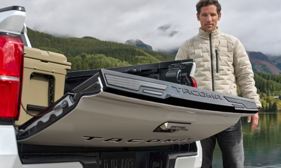 A man in a white jacket watches the power liftgate on a 2024 Toyota Tacoma lower