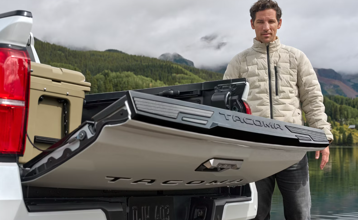 A man in a white jacket watches the power liftgate on a 2024 Toyota Tacoma lower