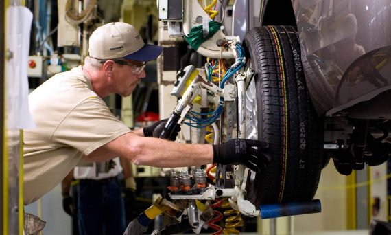 A service technician performing maintenance on a vehicle wheel