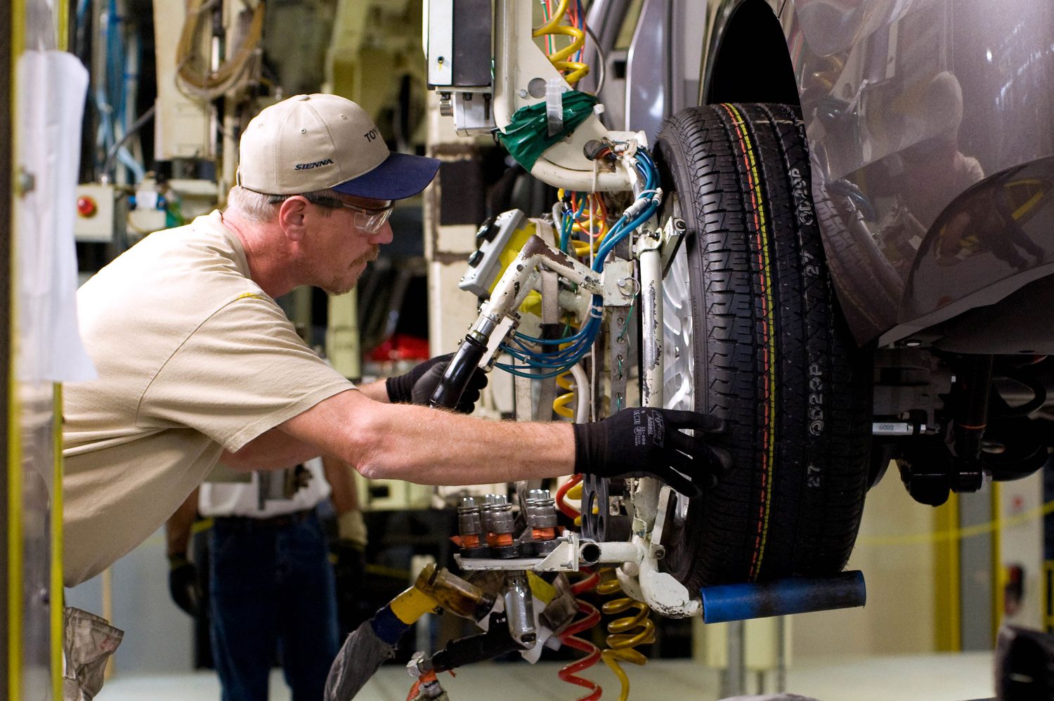 A service technician performing maintenance on a vehicle wheel