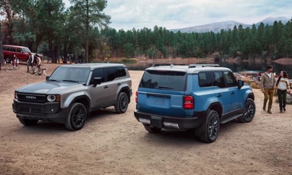 Two 2025 Toyota Land Cruisers parked at a lakeside campsite